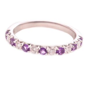 This 14k white gold band features alternating round brilliant cut d...