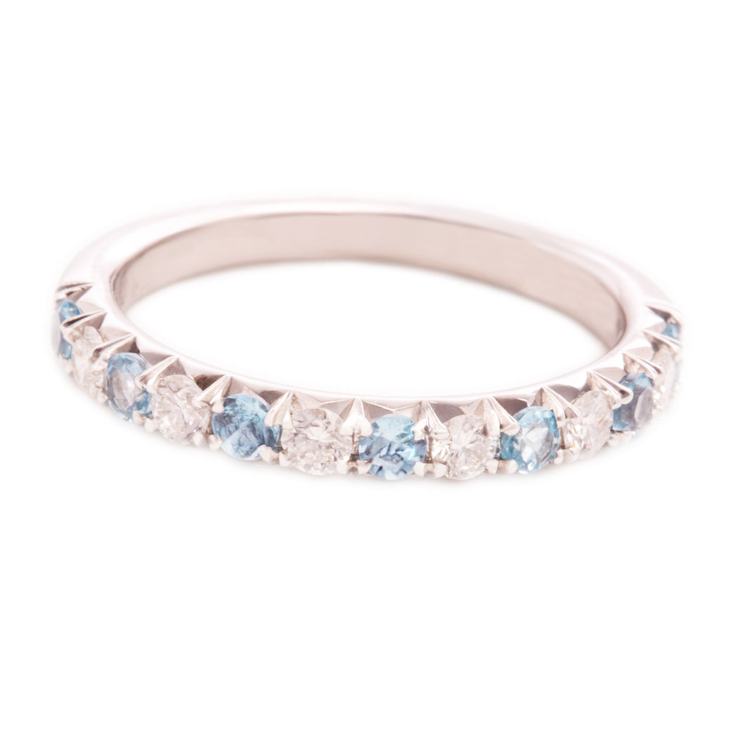 This 14k white gold band features alternating round brilliant cut d...