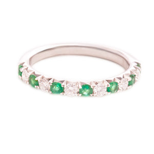 This 14k white gold band features alternating round brilliant cut d...