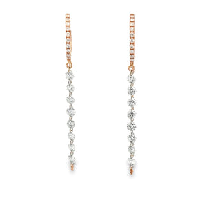 These 14k rose gold huggy earrings feature round brilliant cut diam...
