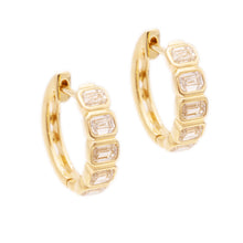 These 14k yellow gold huggy earrings feature 10 emerald cut diamond...