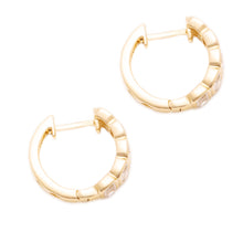 These 14k yellow gold huggy earrings feature 10 emerald cut diamond...
