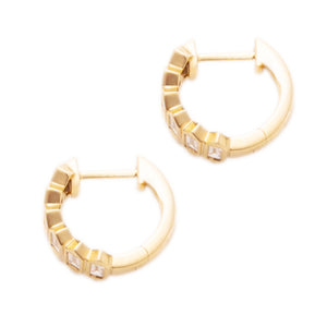 These 14k yellow gold huggy earrings feature baguette cut diamonds ...