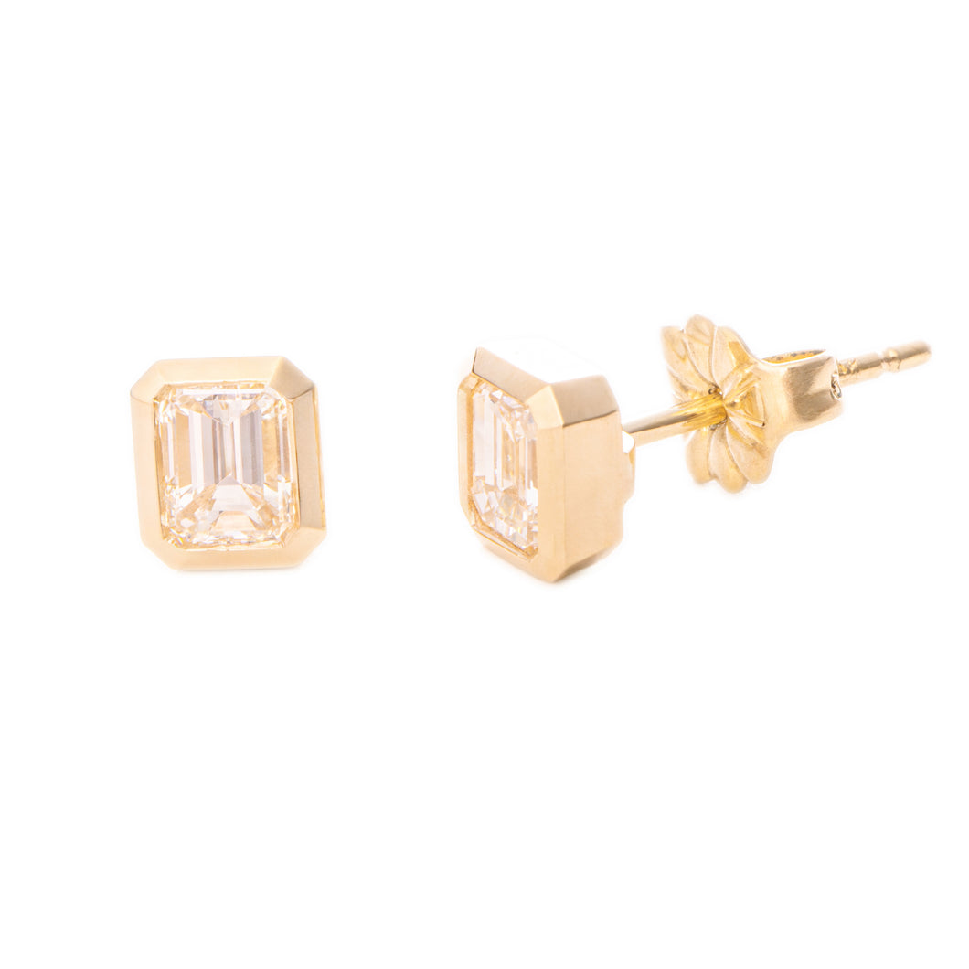 These beautiful 14k yellow gold stud earrings feature 2 emerald cut...