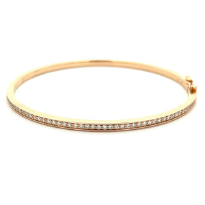 This 14k rose gold diamond bangle features round brilliant cut diam...