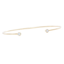 This 14k yellow gold cuff bangle features 2 bezel-set round brillia...