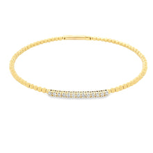 This easy to stack 14k yellow gold bangle features 13 round brillia...