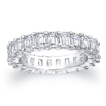 Emerald cut diamonds are set in a continuous circle using shared pr...