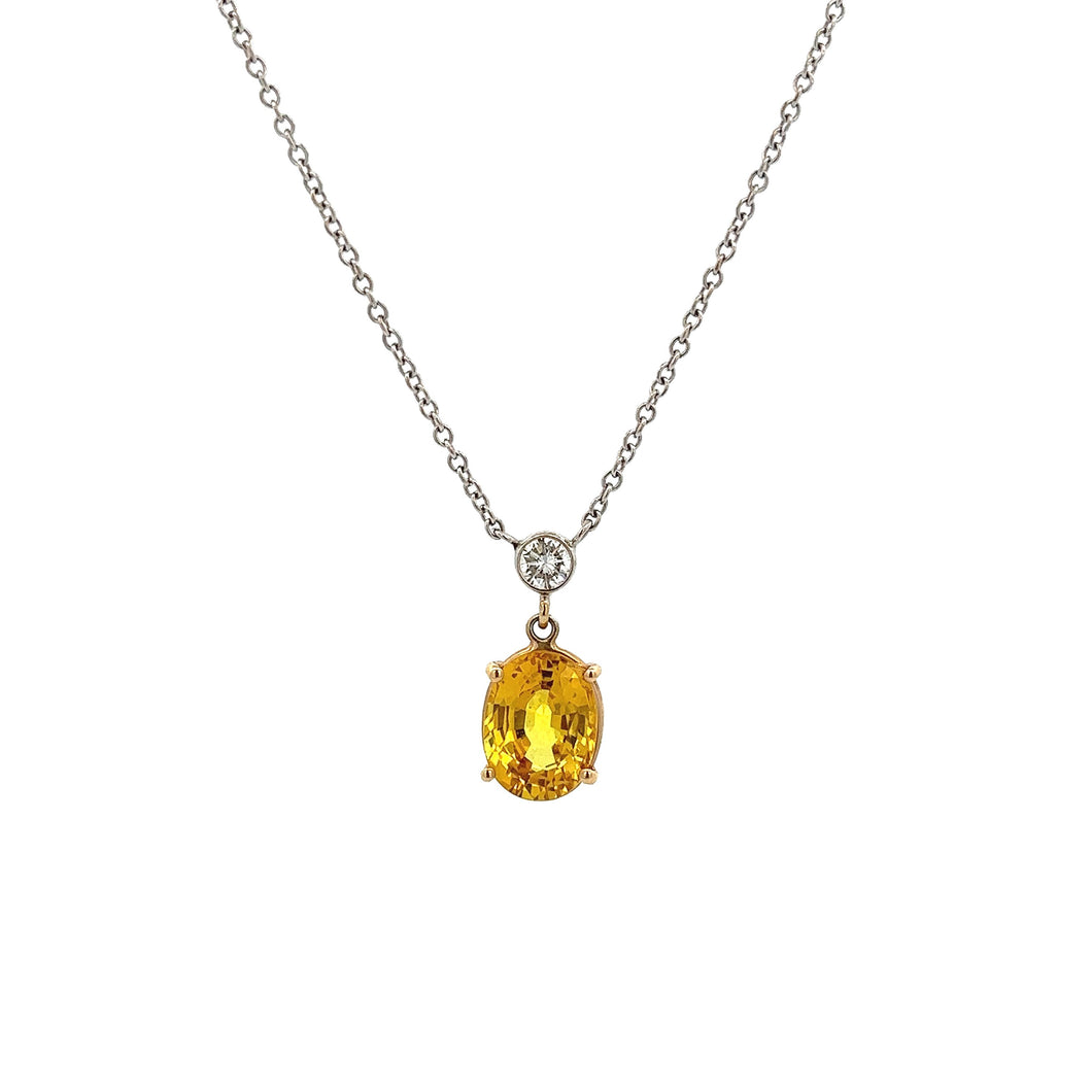 This gorgeous 14k white gold pendant features a yellow sapphire tha...