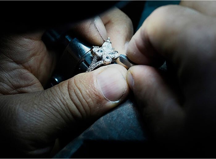 Christopher Designs master jeweler setting a diamond