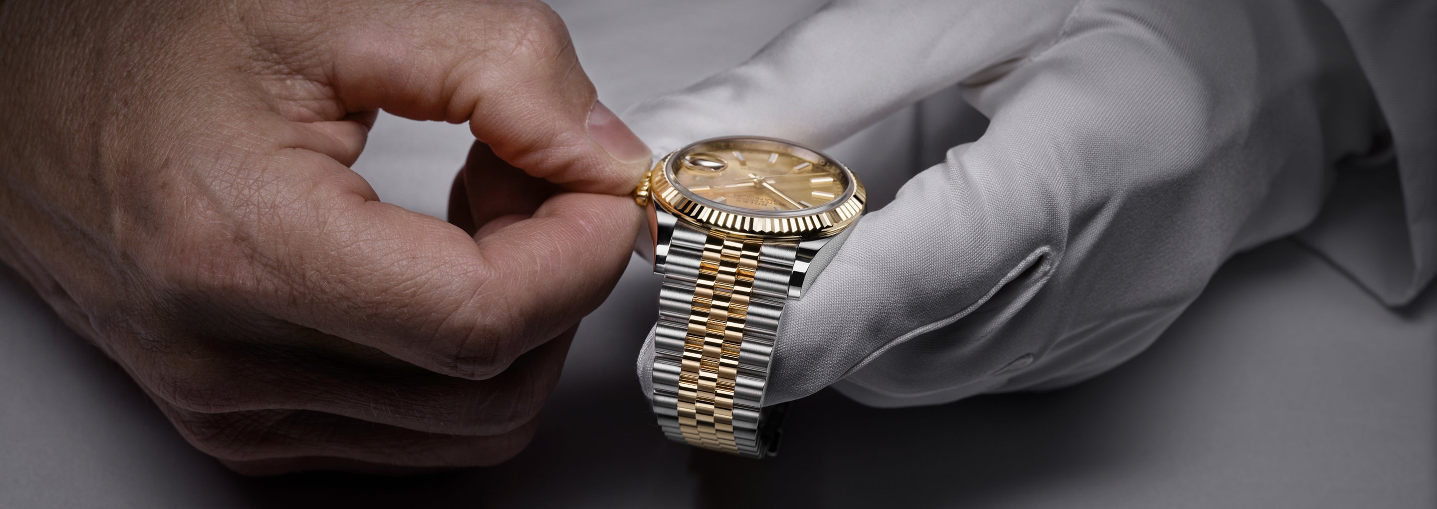Rolex watch held in a gloved hand