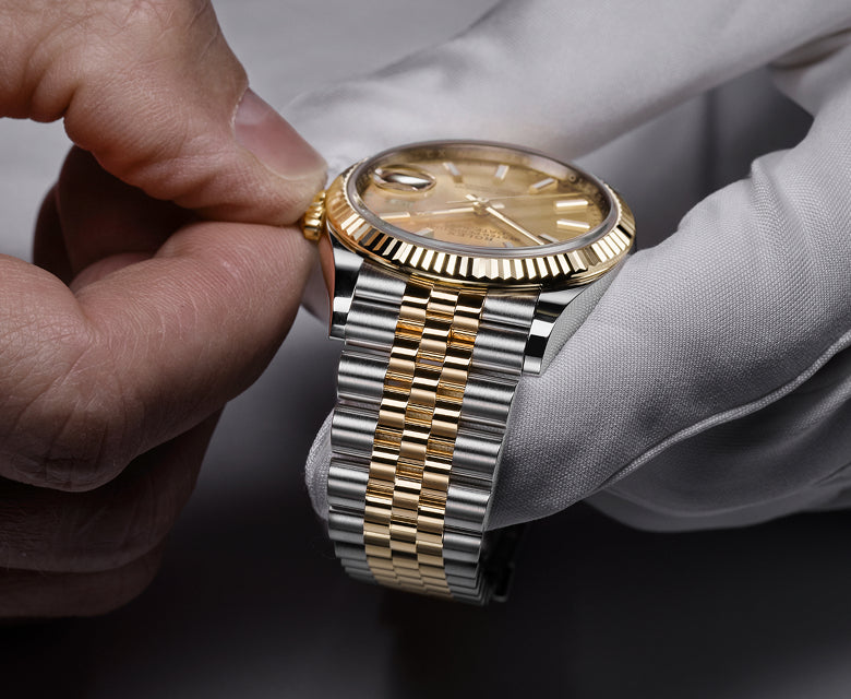 Rolex watch held in a gloved hand
