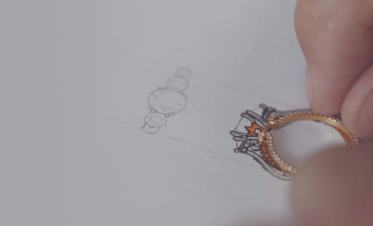 Verragio engagement ring held above its original hand-drawn design sketch