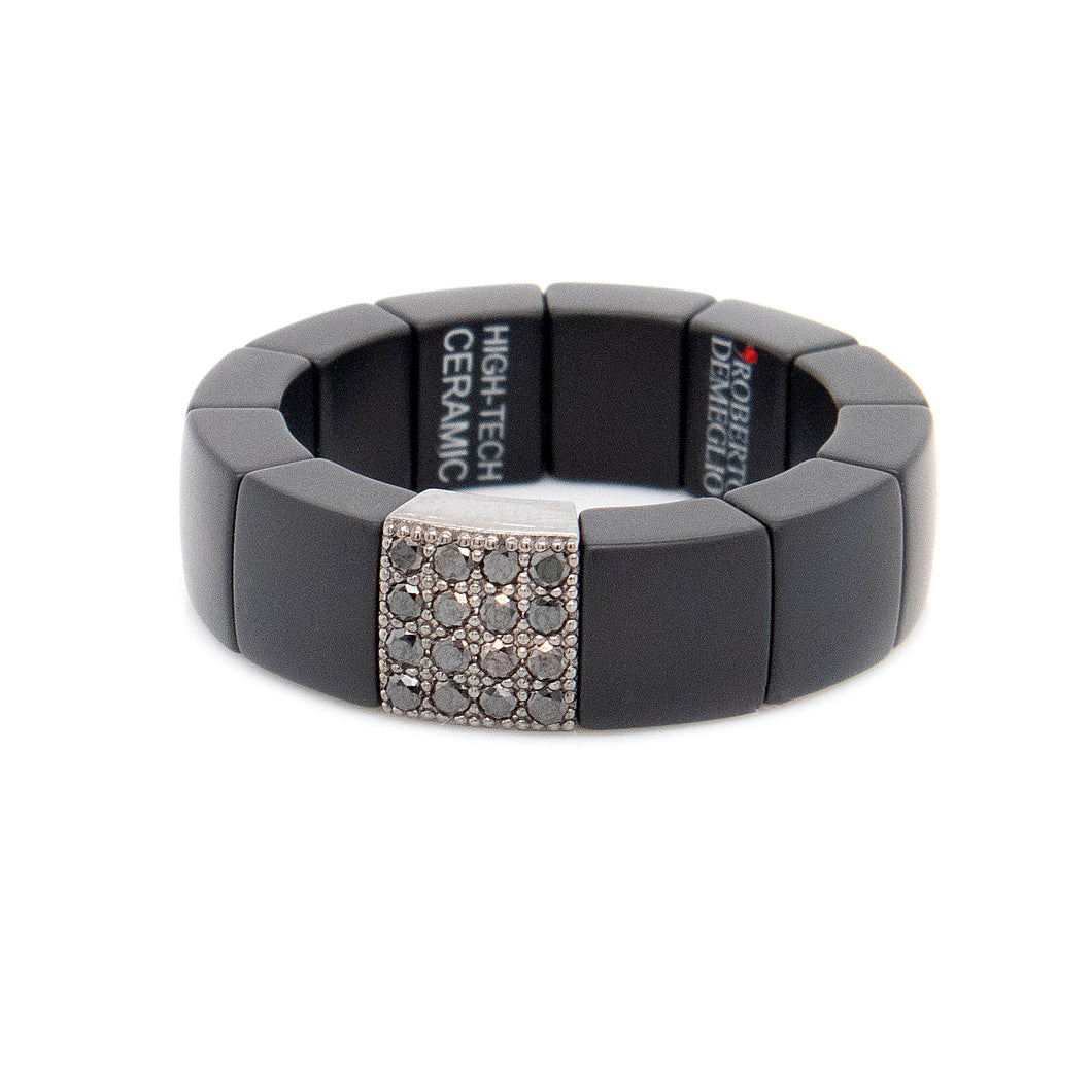 Black ceramic ring on stretch coil band features black diamonds tot...