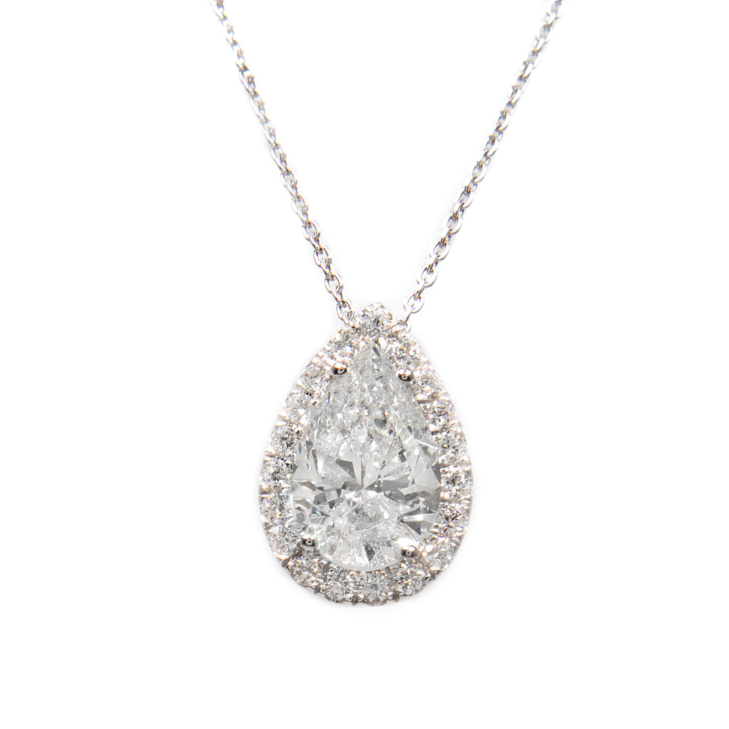 This 18k white gold necklace features a pear shaped center diamond ...