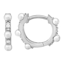 These diamond huggy earrings feature small pearls with .04cts of ro...