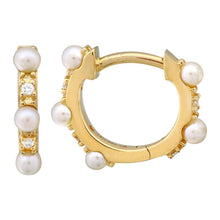 These diamond huggy earrings feature small pearls with .04cts of ro...