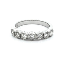 This stackable 18k white gold diamond band features 7 bezel set dia...