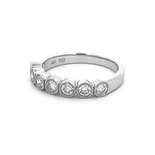 This stackable 18k white gold diamond band features 7 bezel set dia...