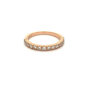This stackable 14k rose gold diamond band features 14 bezel set dia...