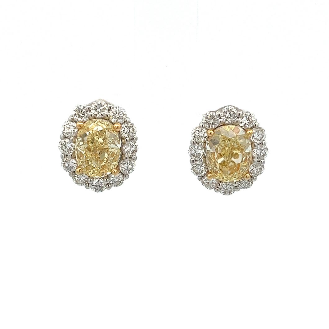 These gorgeous stud earrings feature 2 oval shape fancy yellow diam...