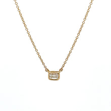 A .30ct emerald cut diamond is bezel-set in this solitaire pendant....