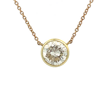 This classic bezel-set pendant is made in 14k yellow and white gold...