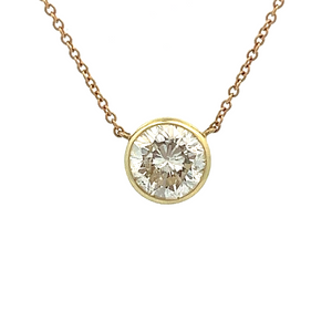 This classic bezel-set pendant is made in 14k yellow and white gold...