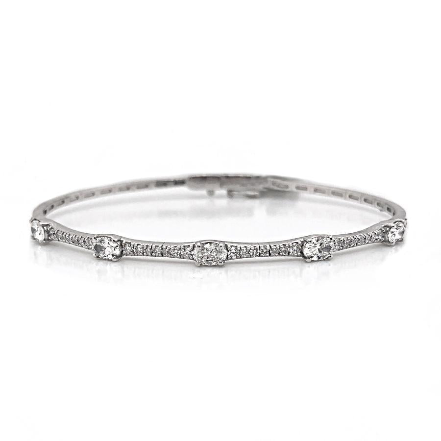 This bangle features oval and round brilliant cut diamonds that tot...