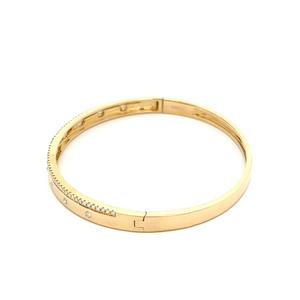 This 14k yellow gold bangle features round brilliant cut and baguet...