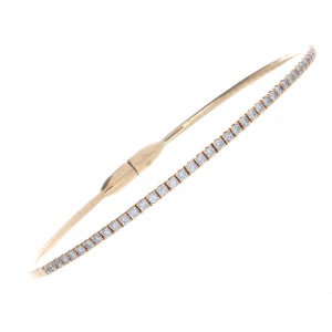 This 18k yellow gold stretch, tennis style bangle features a magnet...