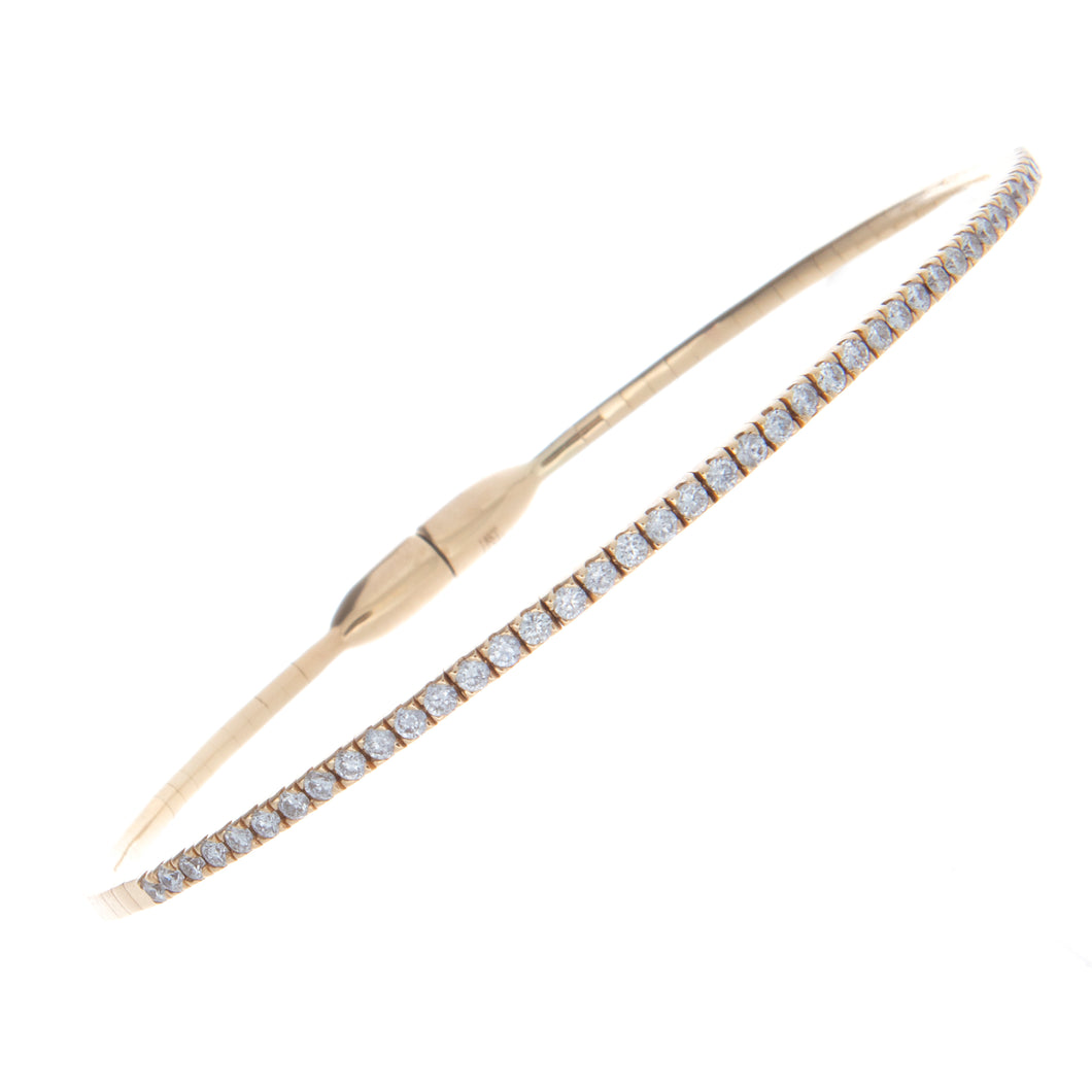 This 18k yellow gold stretch, tennis style bangle features a magnet...