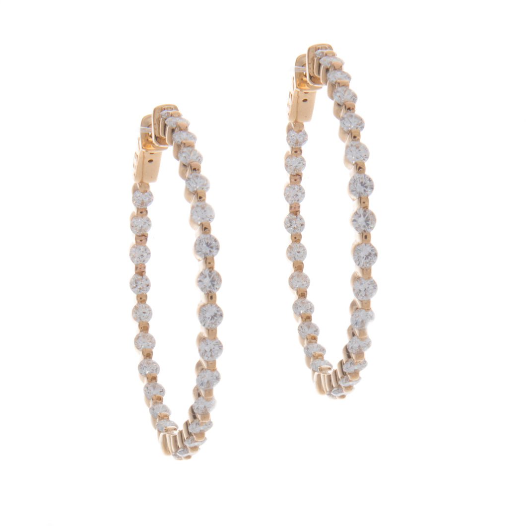 These yellow gold hoops feature round brilliant cut diamonds inside...