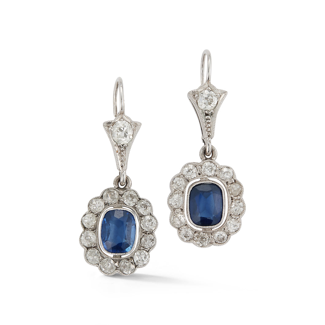 These estate earrings feature sapphires in the center with round di...