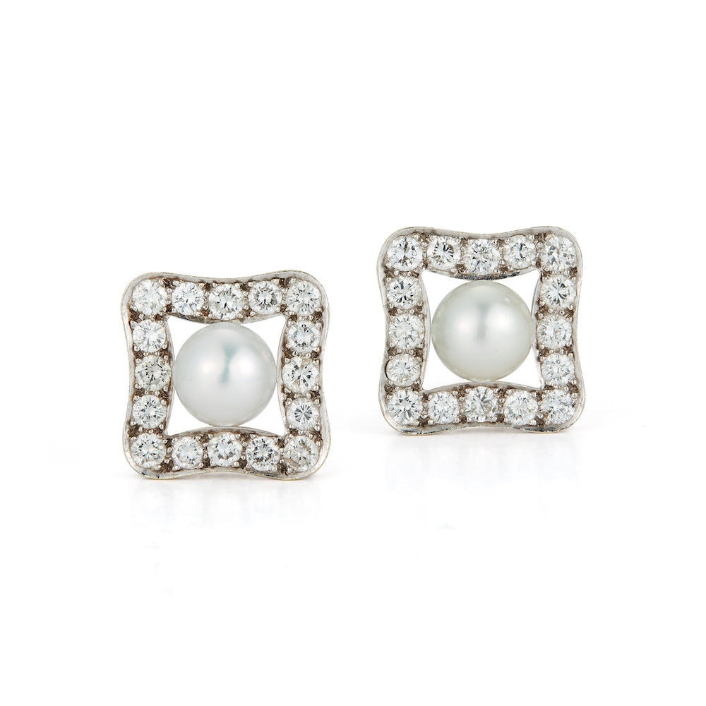 These earrings feature diamonds that total 5.44cts with an 11mm pea...