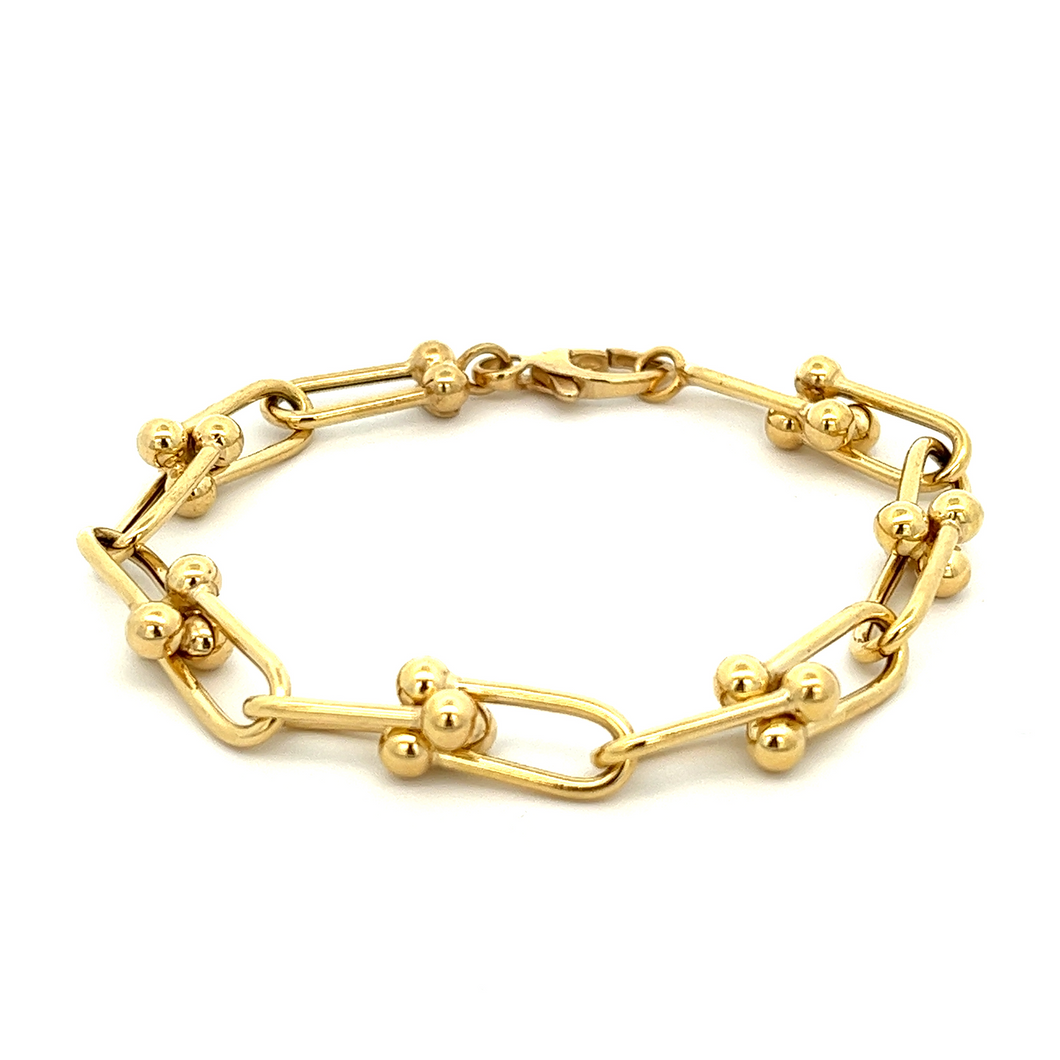 This unique 14k yellow gold bracelet features link chain, ball bear...