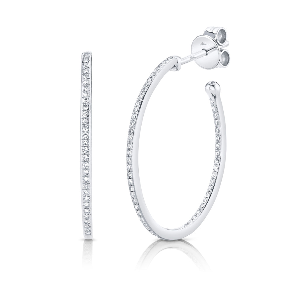 These diamond hoop earrings feature pave set round brilliant cut di...