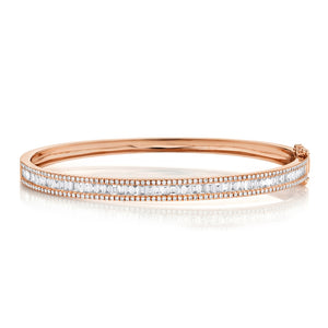 This diamond bangle features round brilliant cut and baguette diamo...
