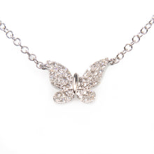 A mini white gold butterfly pendant features diamonds totaling .10c...