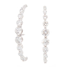These modern and uniquely shaped earrings feature 16 round brillian...