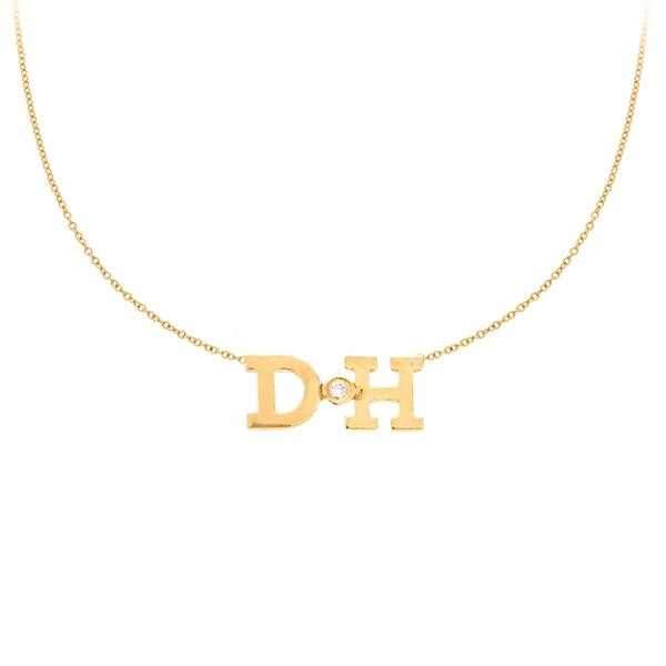 This necklace features two initials with a bezel set diamond in the...
