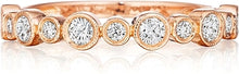 This Henri Daussi wedding band features bezel set round brilliant c...