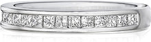 This Henri Daussi wedding band features channel set princess cut di...