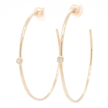 These classic gold hoops feature a bezel set diamond totaling .07ct