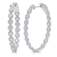 These hoop earrings feature round brilliant cut diamonds that total...