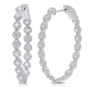 These hoop earrings feature round brilliant cut diamonds that total...