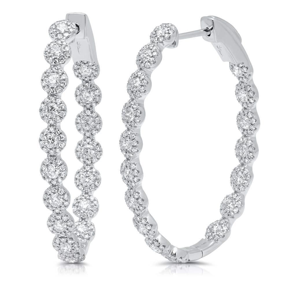 These hoop earrings feature round brilliant cut diamonds that total...